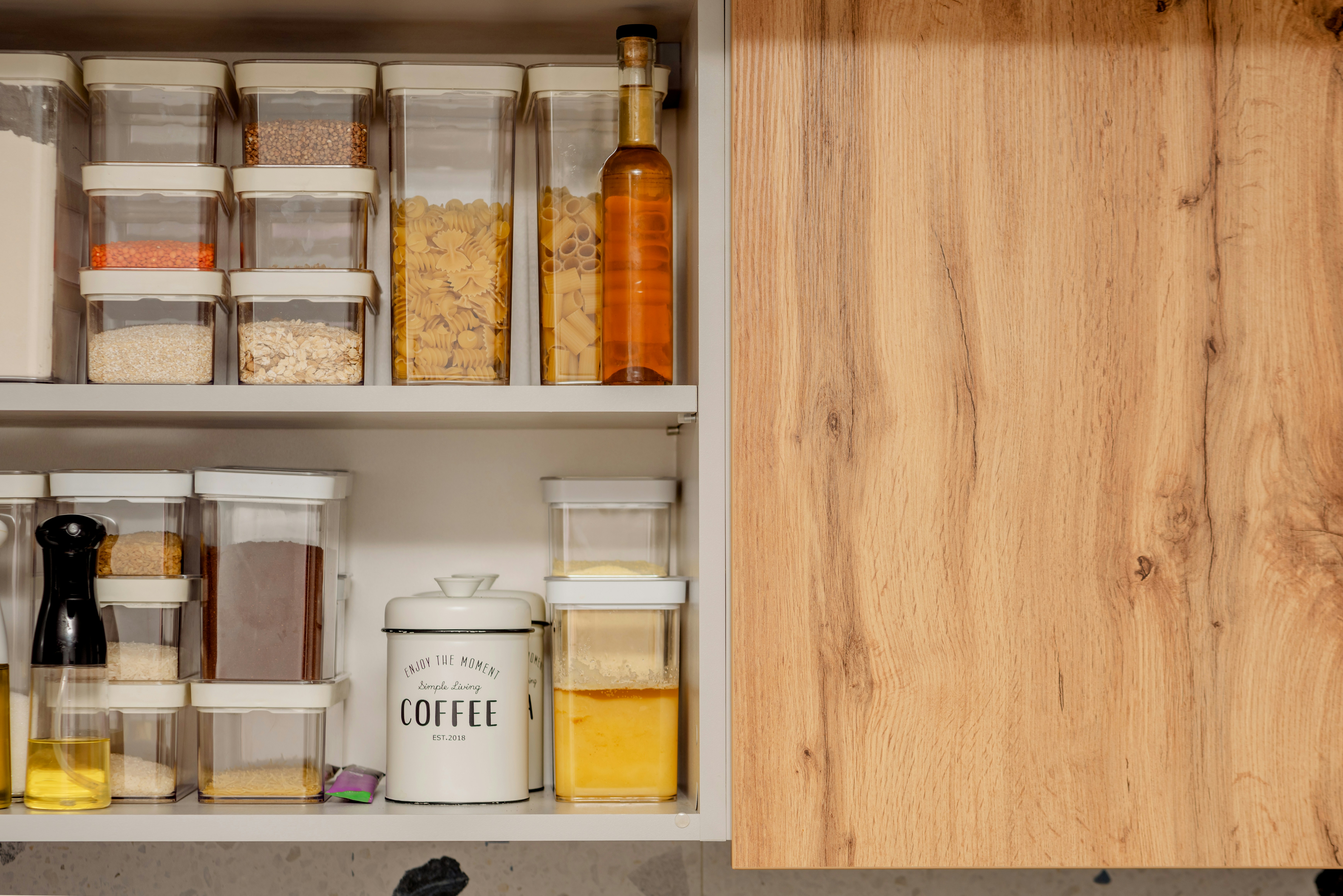 Pull-out pantry system showing multiple shelves with various food items organized and easily accessible - cabinet design kitchen
