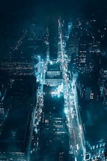 A nighttime aerial shot of a city grid illuminated by streetlights, showcasing a premium urban vibe.