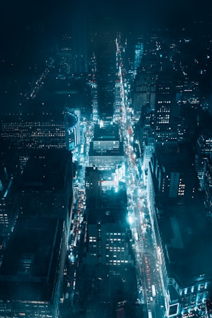 A nighttime aerial shot of a city grid illuminated by streetlights, showcasing a premium urban vibe.