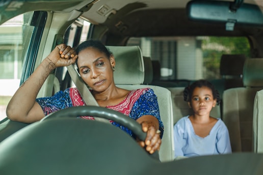 a woman and a child sitting in a car