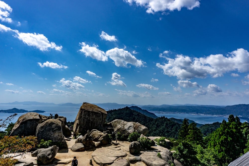 a person standing on top of a rock covered hillside