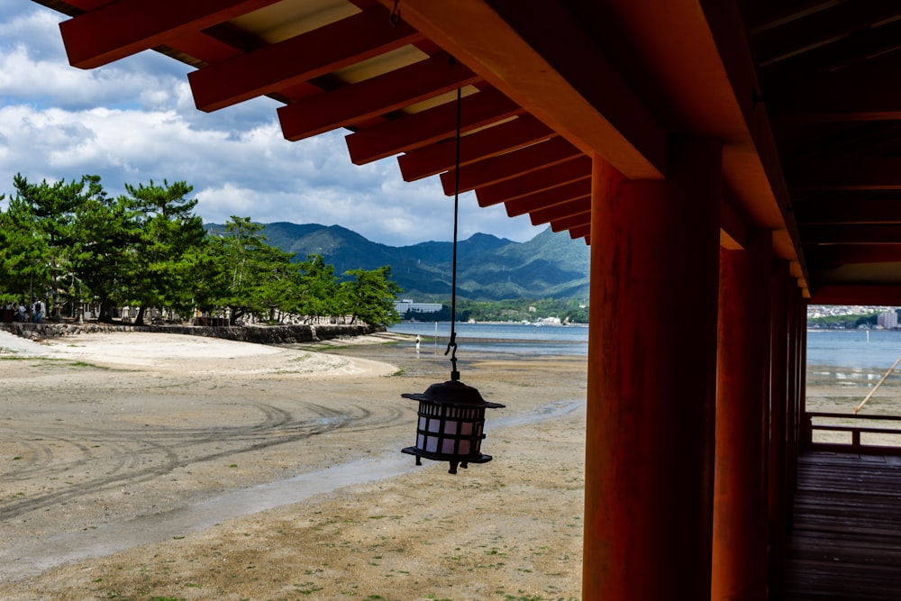 a lantern hanging from a wooden structure on a beach