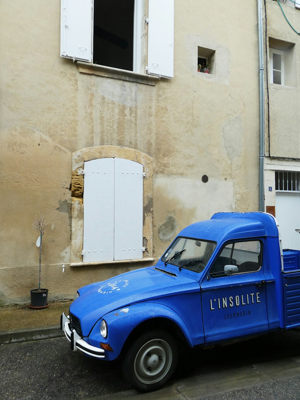 a blue truck parked in front of a building