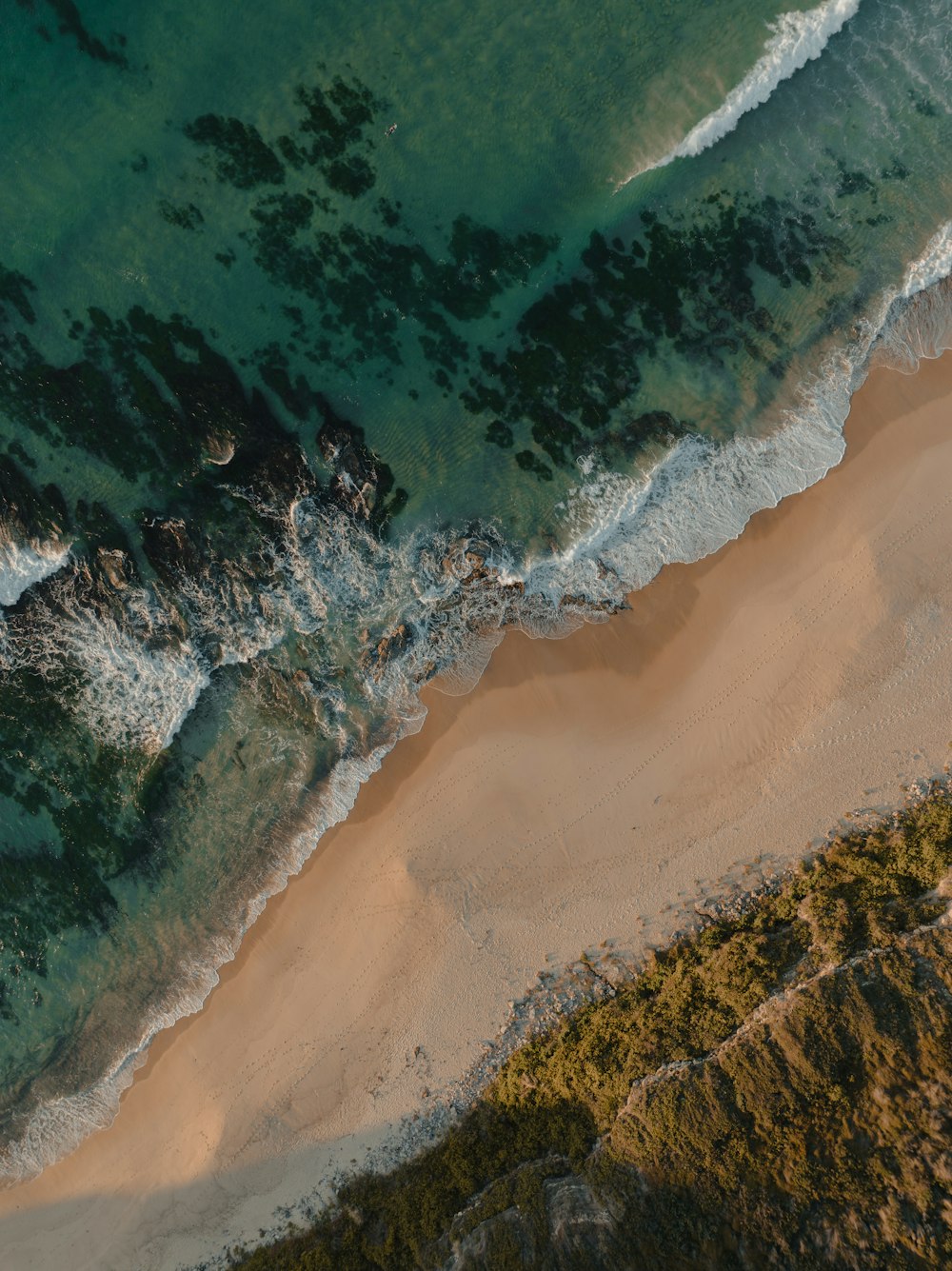 an aerial view of a sandy beach and ocean