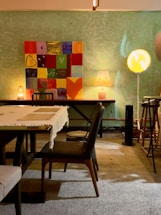 A cozy corner with warm neutral-toned abstract wall art softly lit, inviting calm and conversation.