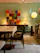 A happy customer hanging a bright, abstract acrylic painting in a cozy, sunlit living room.