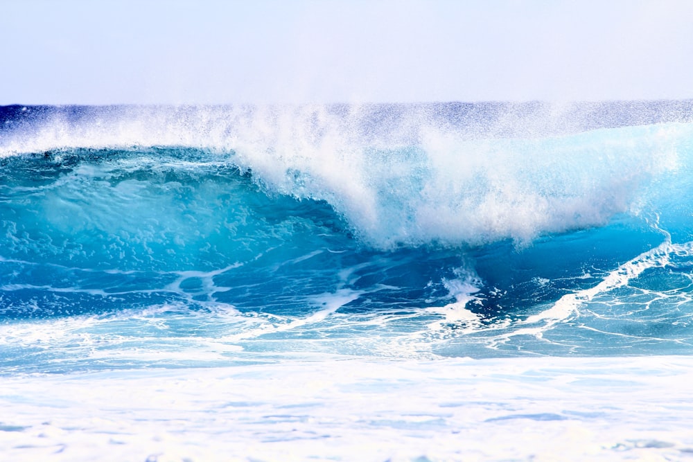 a large blue wave crashing into the ocean