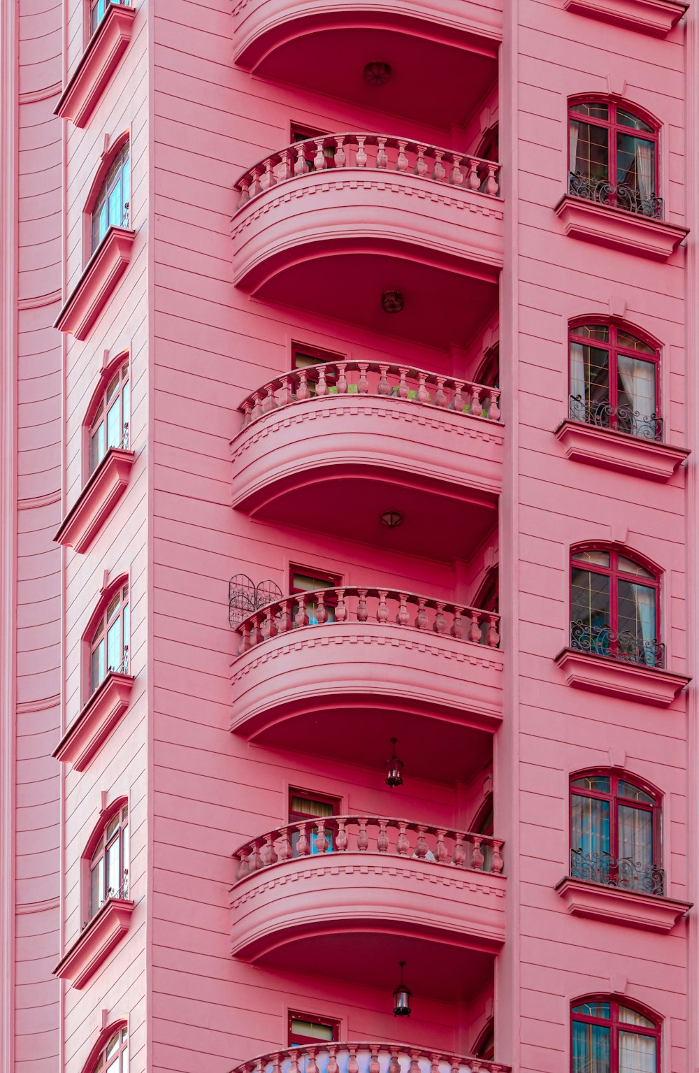 a pink building with balconies and balconies on the balconies