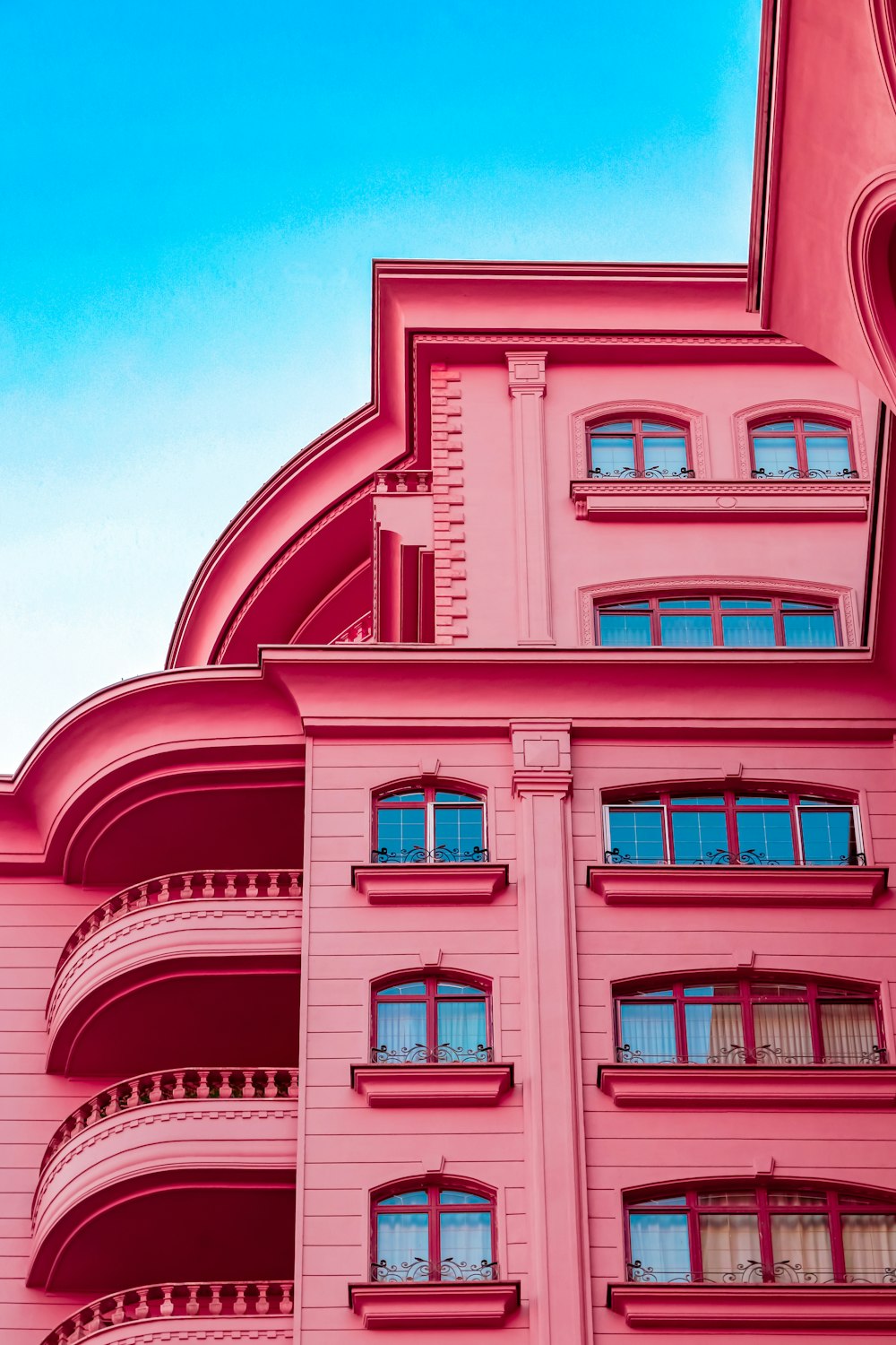 a pink building with balconies and a clock