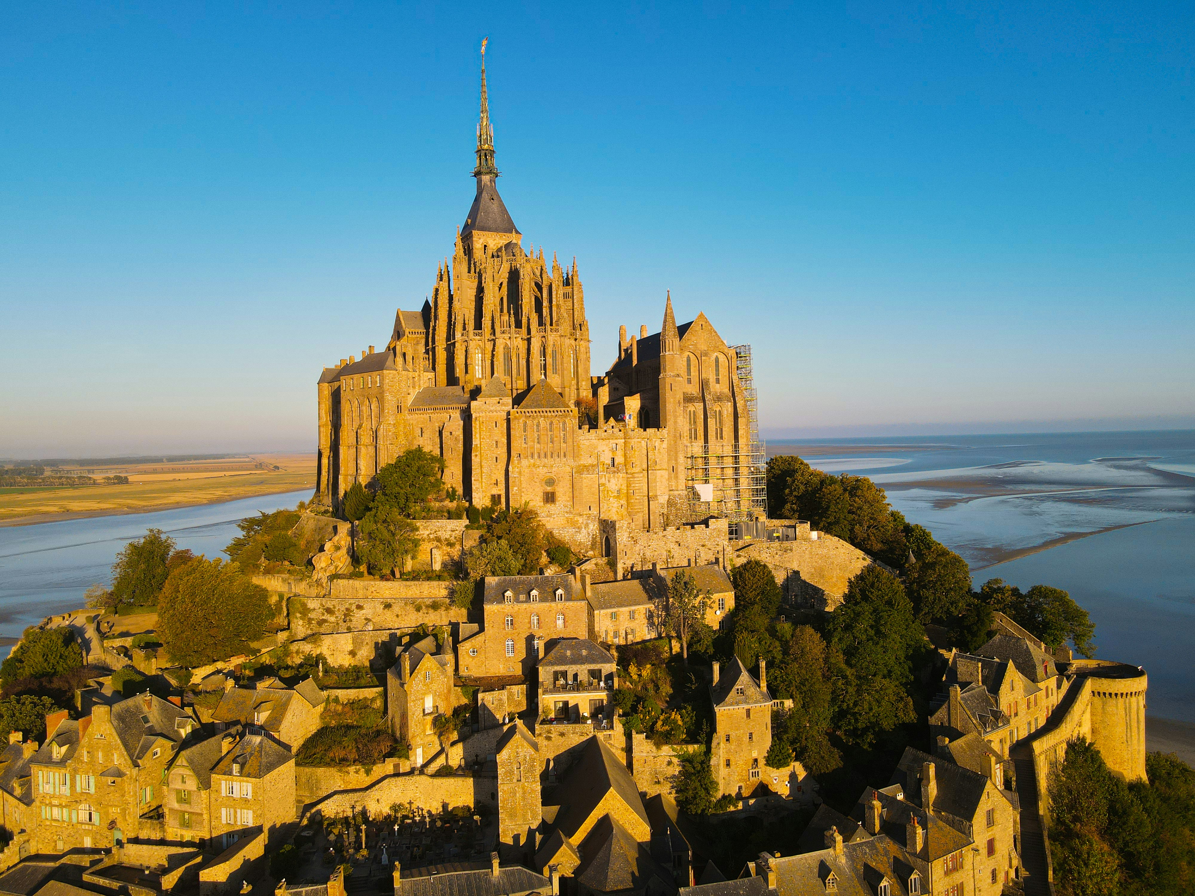 an aerial view of a castle with a lake in the background, 