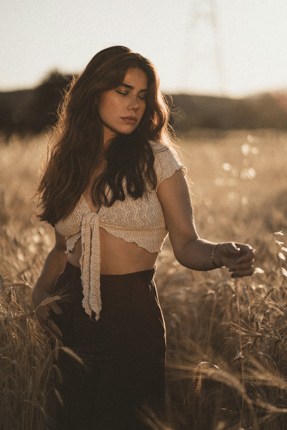 a woman standing in a field of tall grass