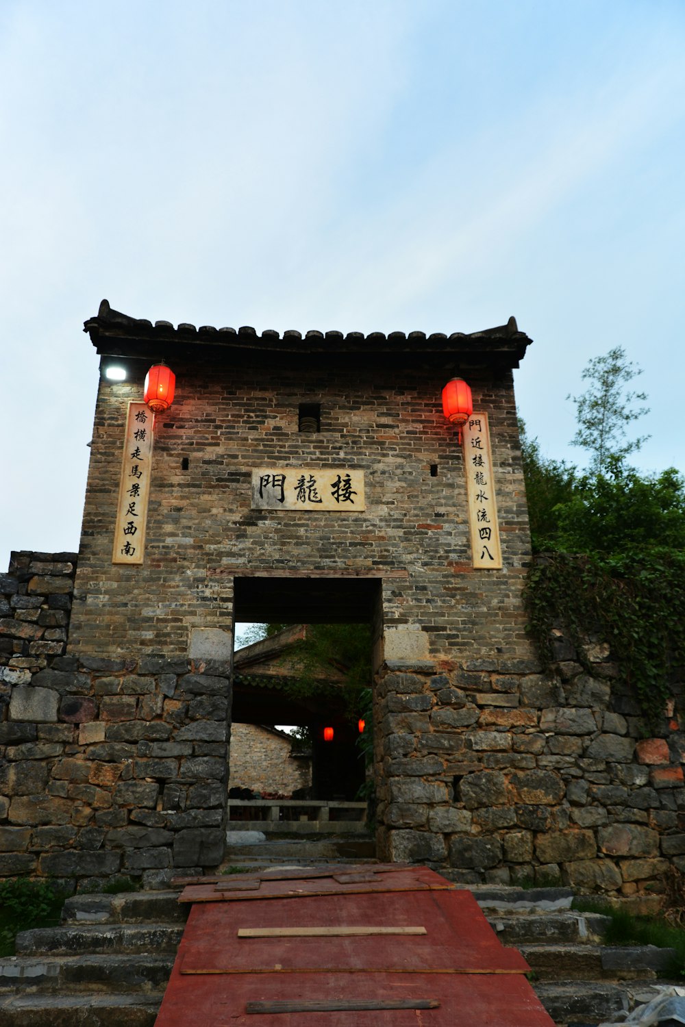 a stone building with red lanterns on top of it