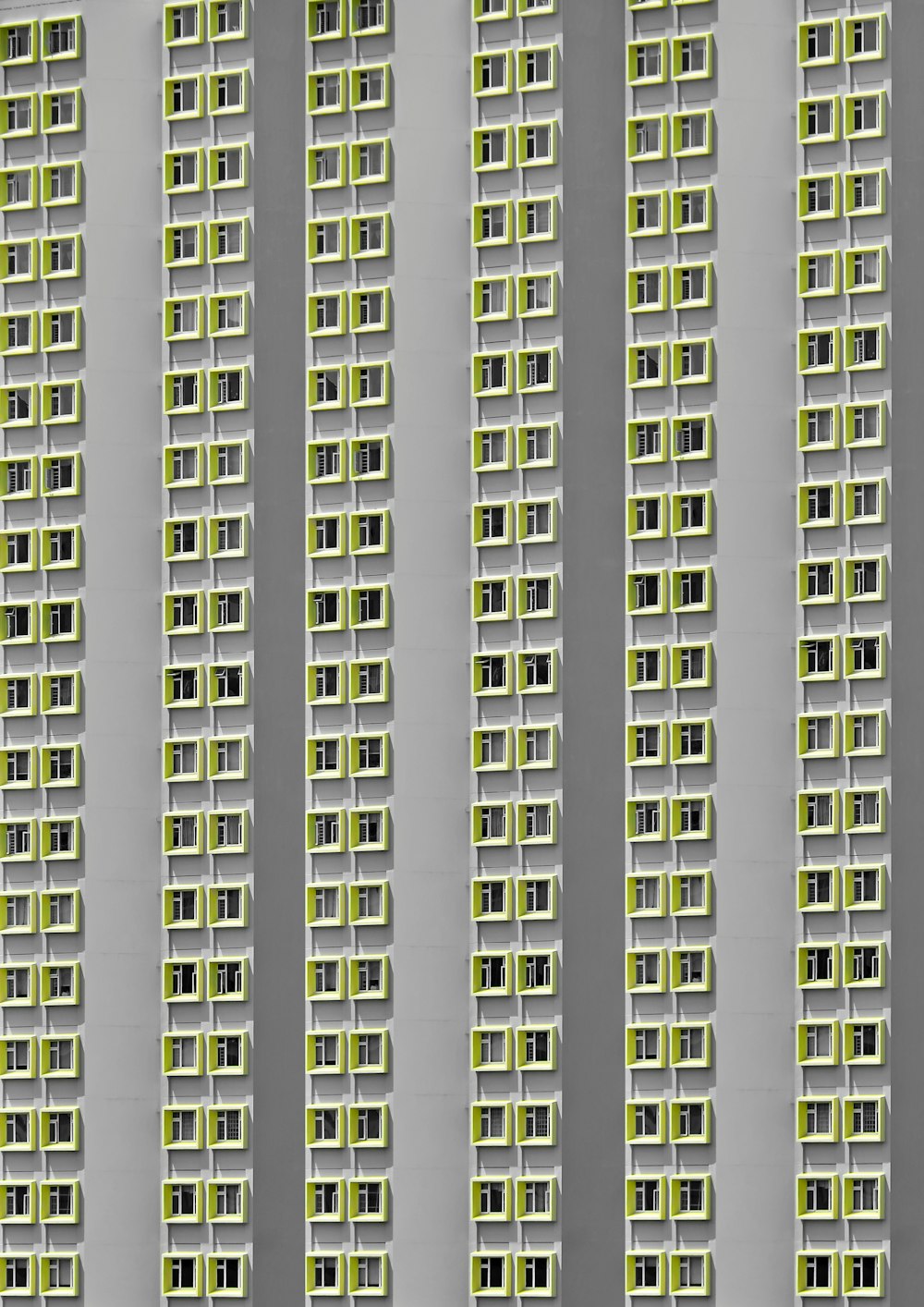 Ein hohes Gebäude mit vielen Fenstern und grünen Fensterläden