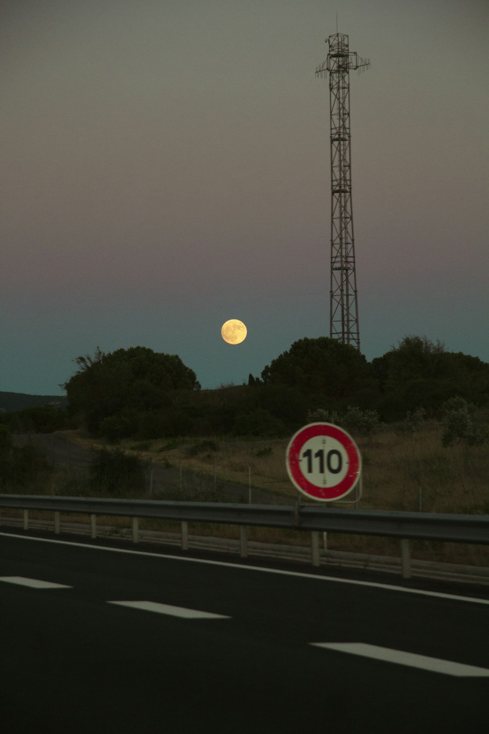 a full moon is seen over a highway
