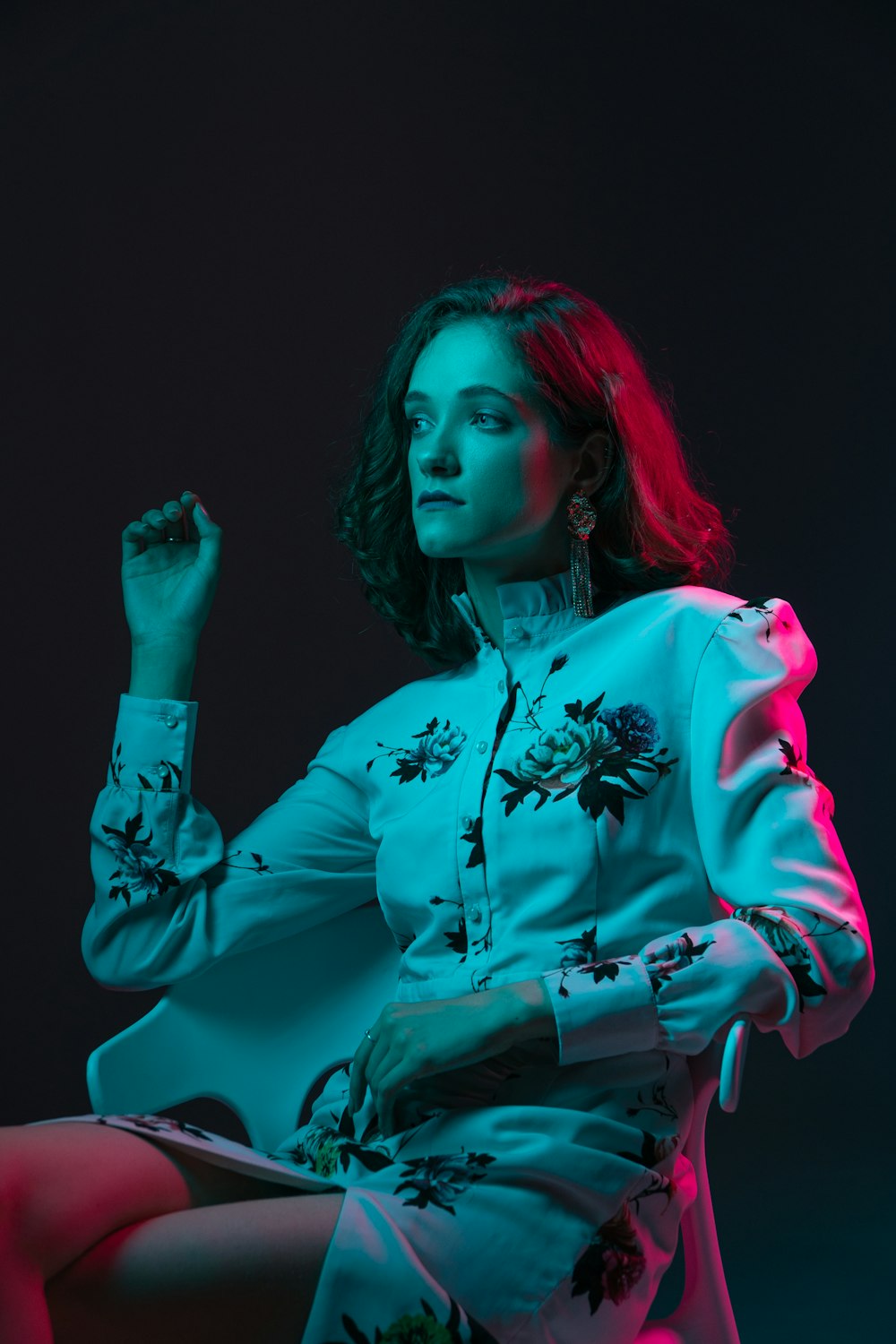 a woman sitting on a chair in a blue dress