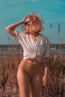 a woman in a short skirt standing on a beach