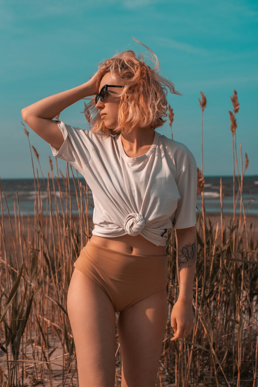 a woman in a short skirt standing on a beach