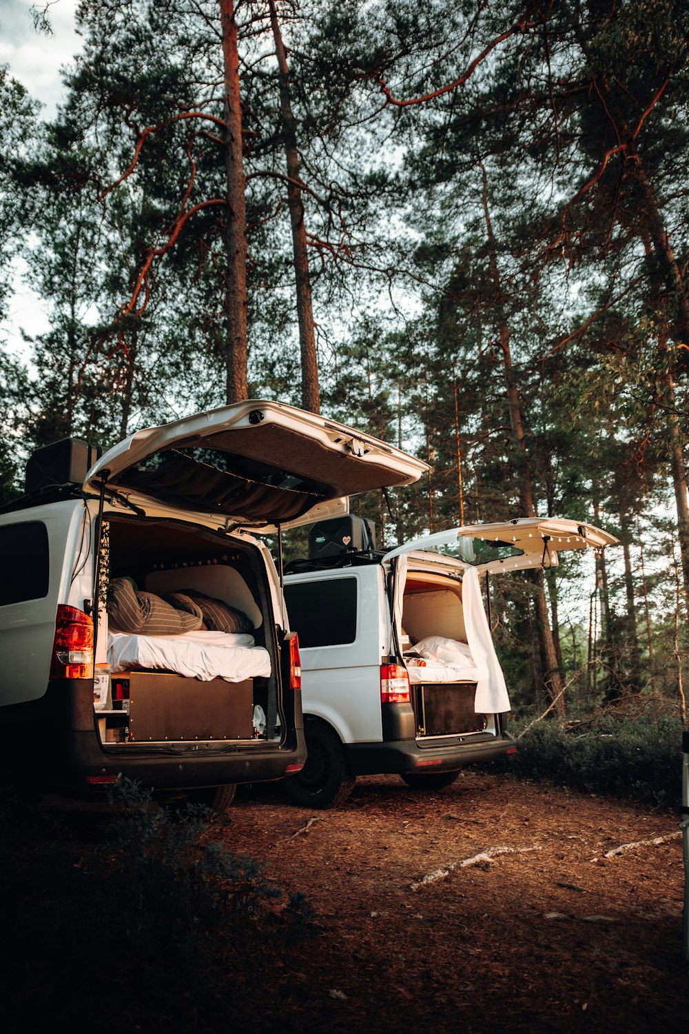 a van with a bed in the back of it parked in the woods