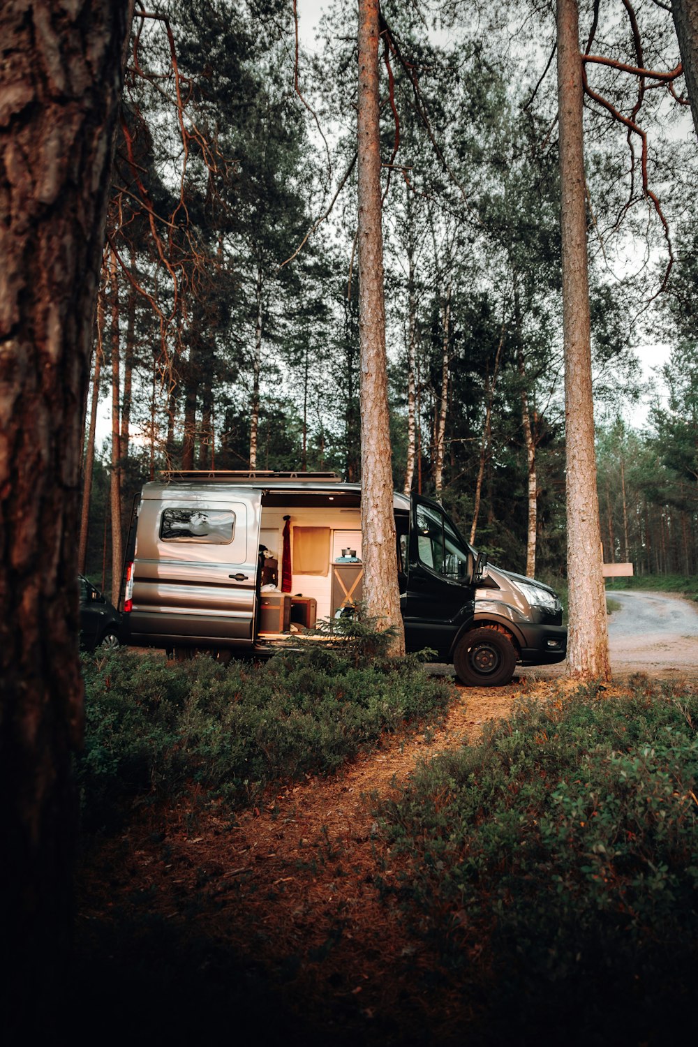 a truck is parked next to a trailer in the woods