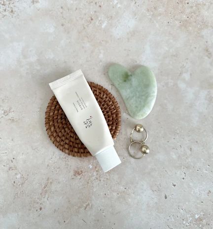 Elegant flat lay of aurelle body products on a creamy linen cloth with muted blush and gold accents.