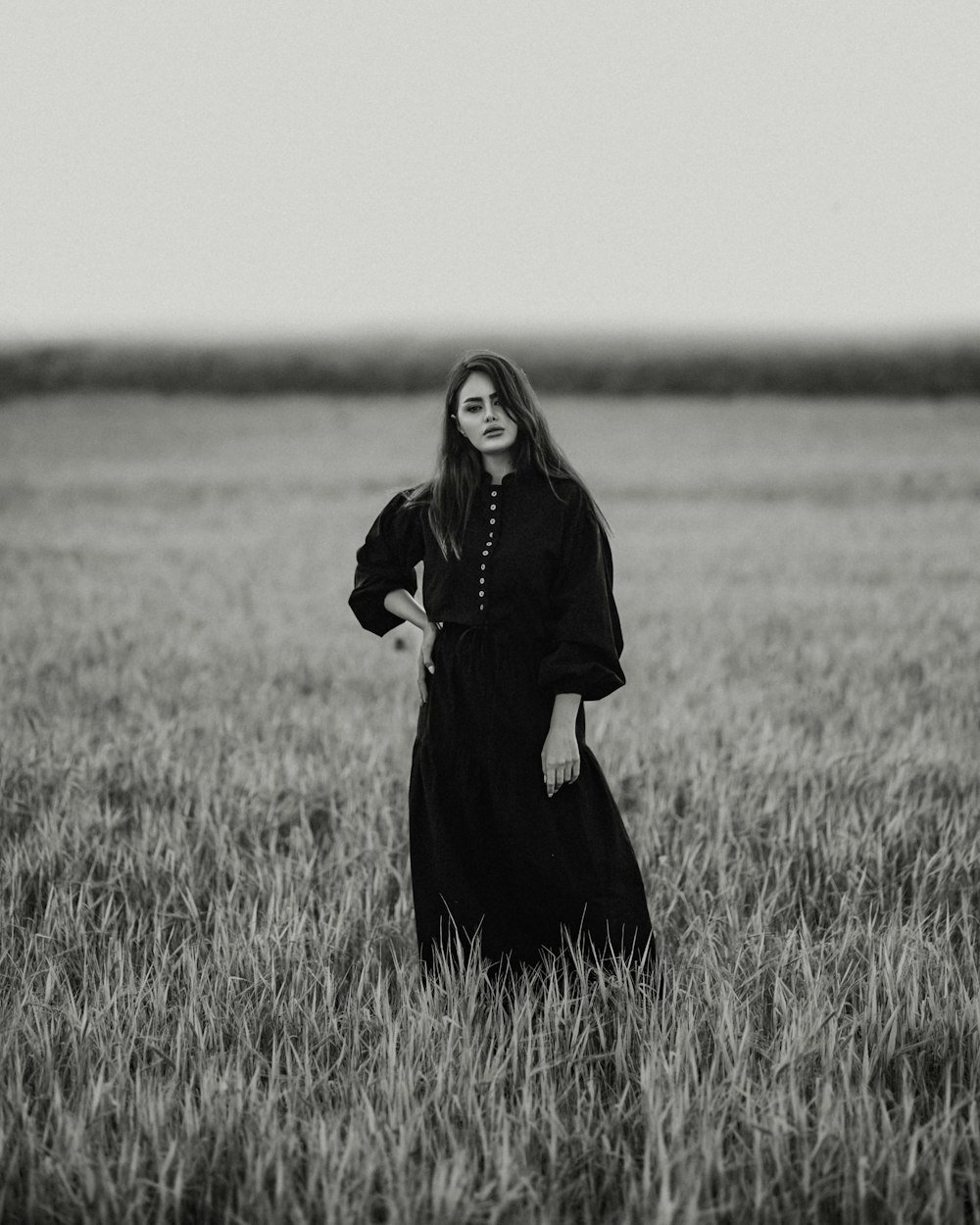 a woman standing in a field of tall grass