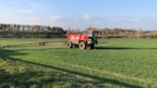 A modern agricultural sprayer machine working in a green field under a clear sky