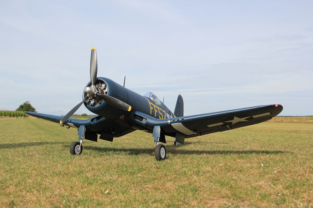 a small airplane sitting on top of a lush green field