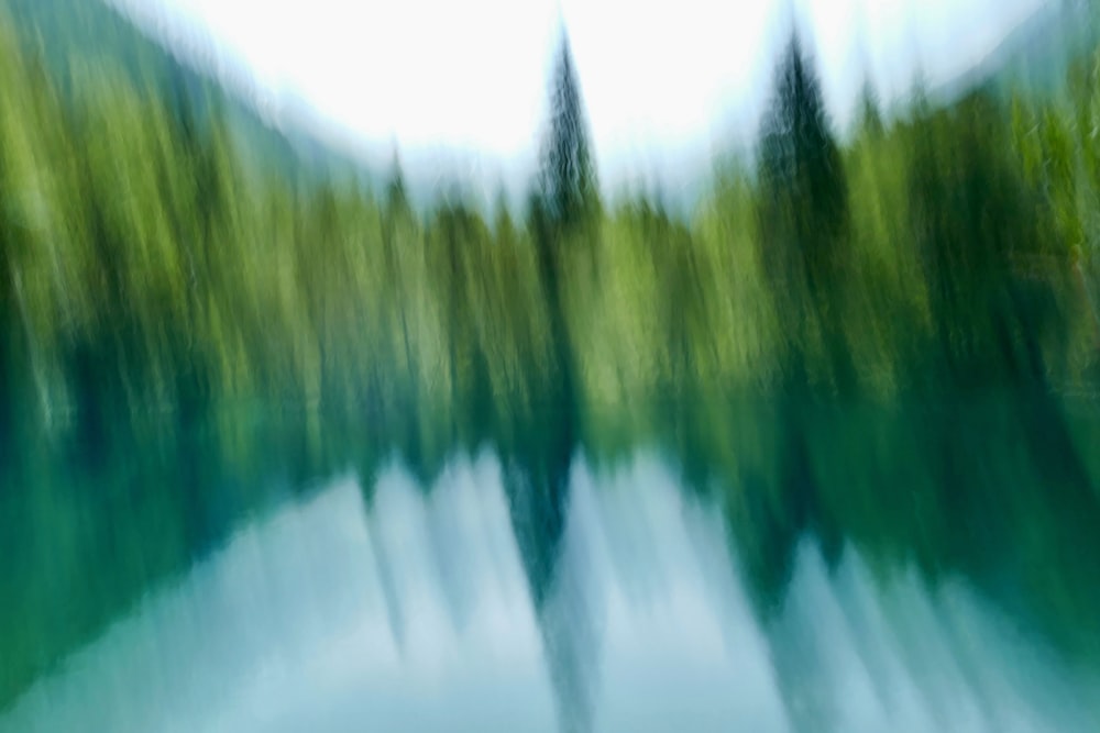 a blurry photo of a lake with trees in the background