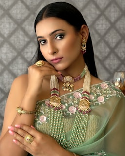 a woman wearing a green sari and jewelry