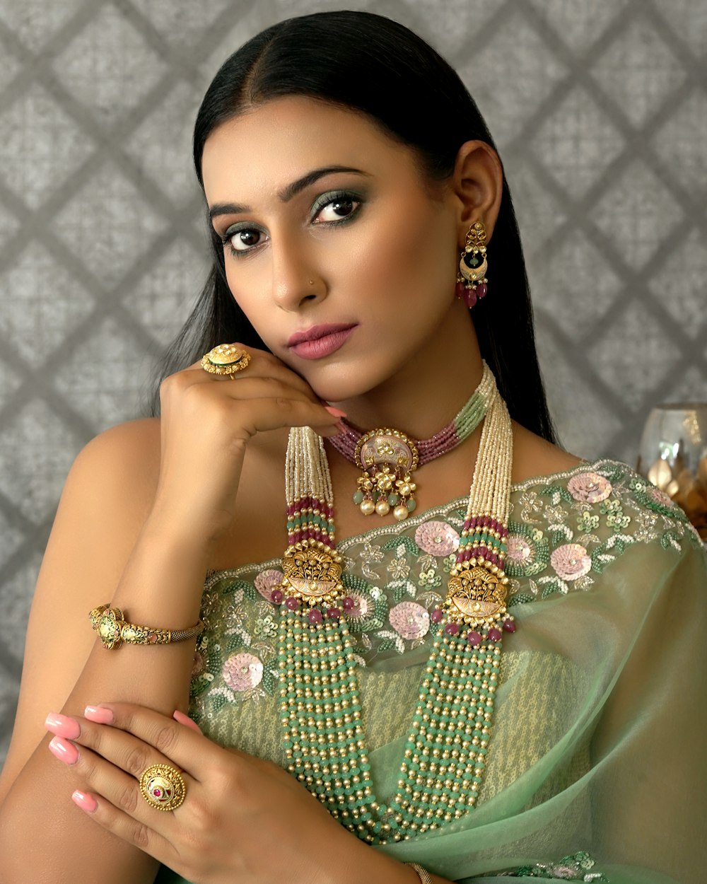 a woman wearing a green sari and jewelry