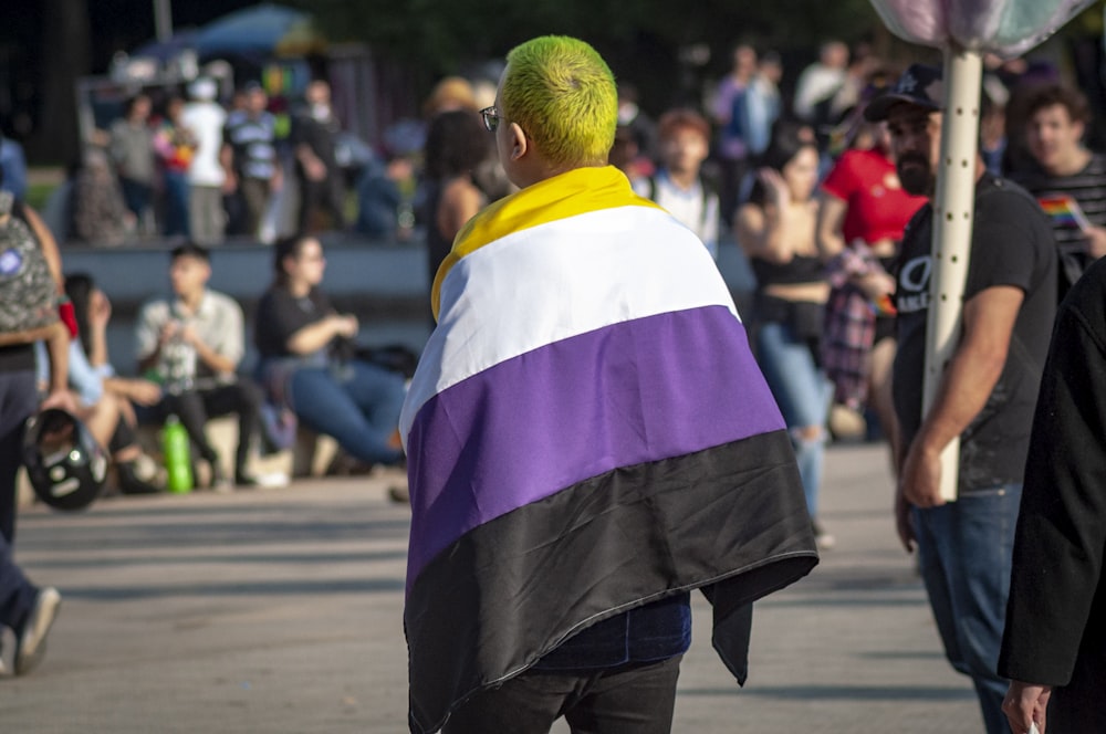 a man with green hair wearing a colorful cape