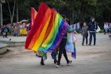 Wide-angle shot of a peaceful park scene with subtle rainbow flags.