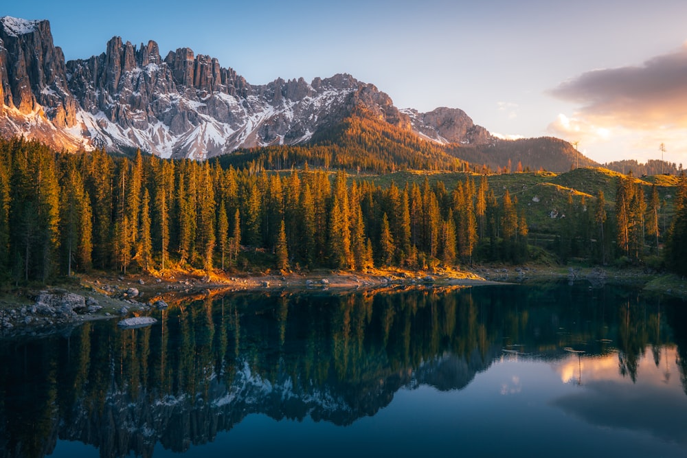 a mountain range with a lake surrounded by trees