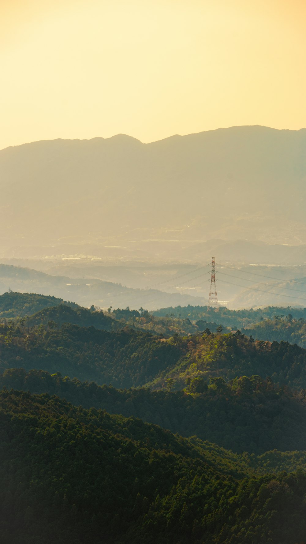 a view of a mountain range with a radio tower in the distance