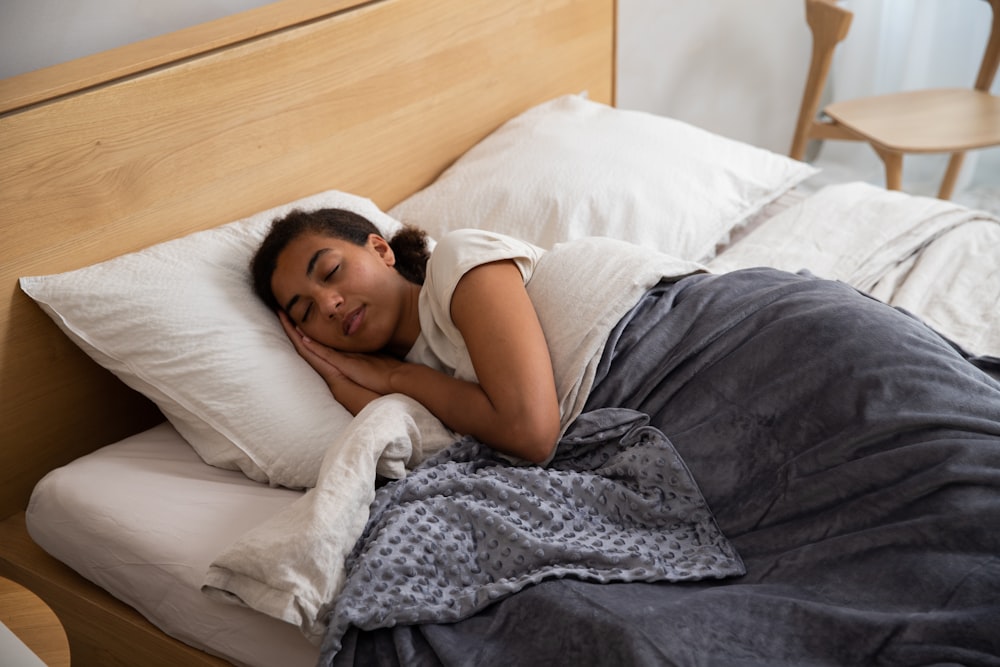 a woman laying in bed with her head on a pillow