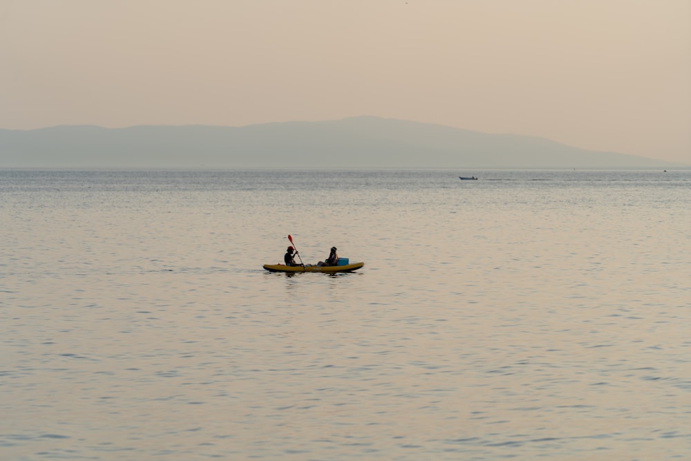a couple of people in a small boat on a large body of water