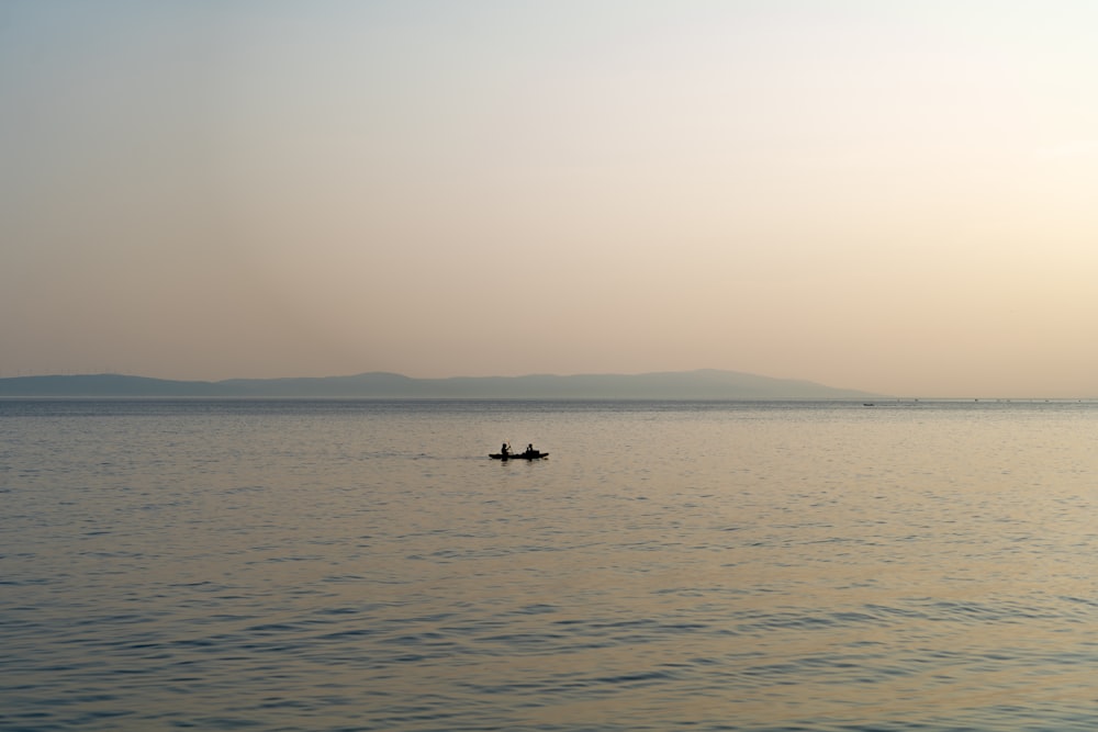 a person in a small boat on a large body of water