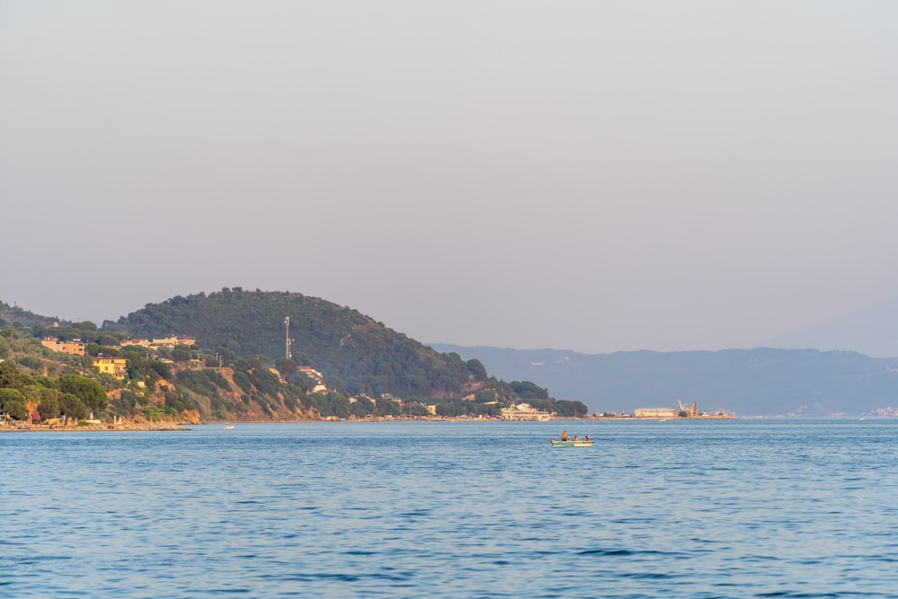 a body of water with a hill in the background