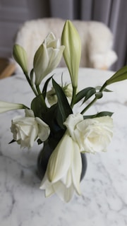 An elegant ceramic vase with fresh wildflowers sitting on a sleek marble countertop.