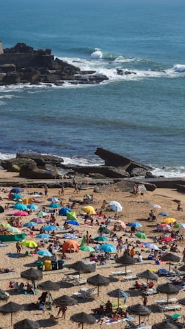 A lively beach scene at Copacabana with people playing volleyball and relaxing under umbrellas.