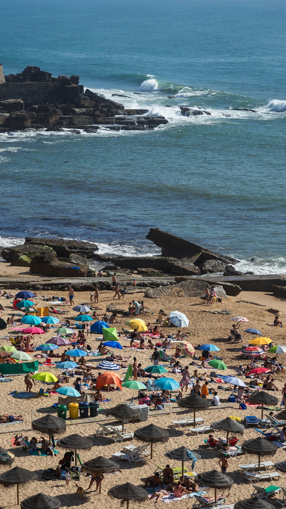 a beach filled with lots of people and umbrellas