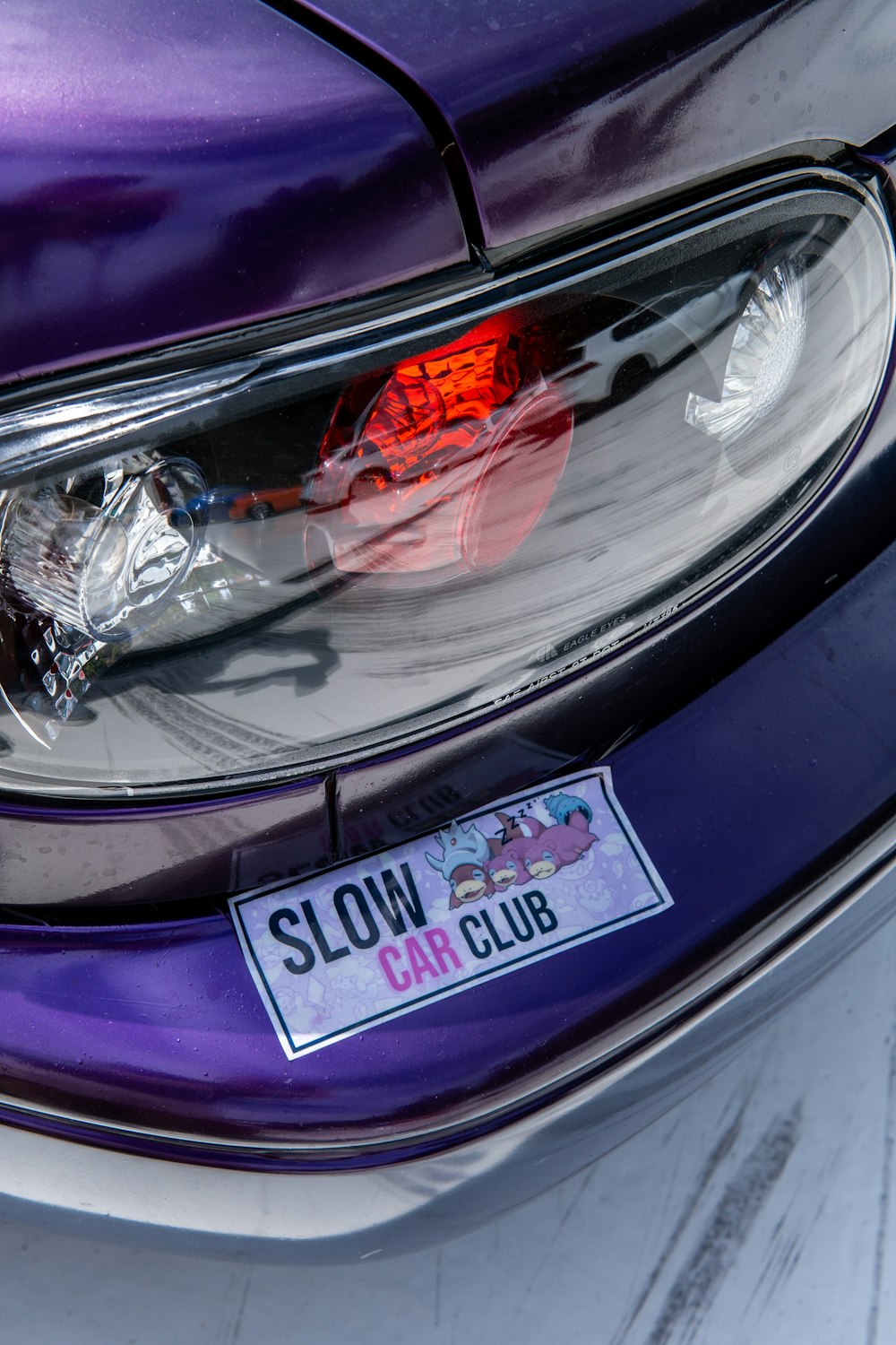 a purple car with a slow car club sticker on it