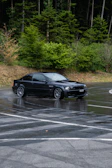A sleek sports car speeding through a rain-soaked urban highway.
