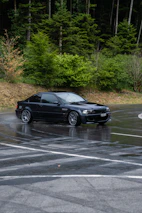 A sleek car driving confidently on a winding road, showcasing quality tires.