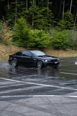 A sleek sports car speeding through a rain-soaked urban highway.