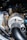 A close-up view of a turbocharger system in an engine bay, featuring metallic tubes and pipes wrapped in heat-resistant material, with the BorgWarner logo visible. The components have a mix of polished and textured surfaces.