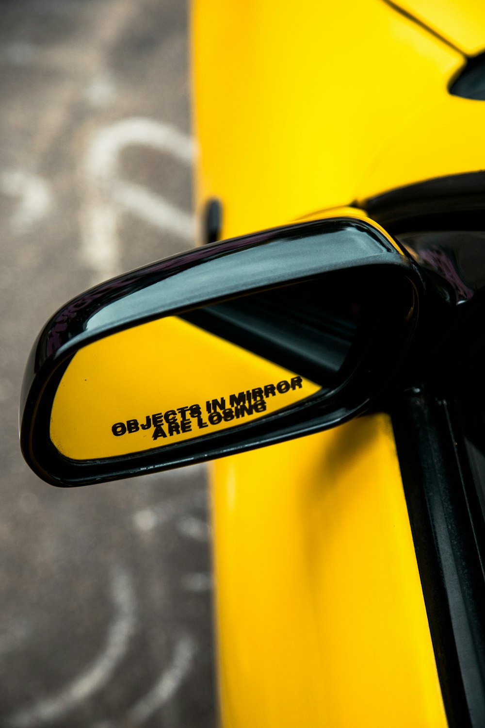 Lo specchietto laterale di un'auto sportiva gialla