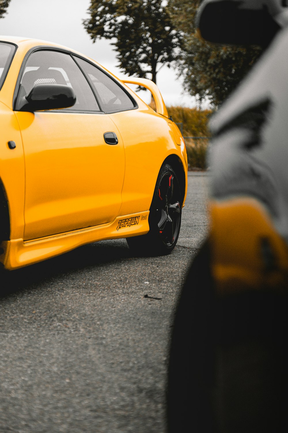 a yellow sports car parked on the side of the road