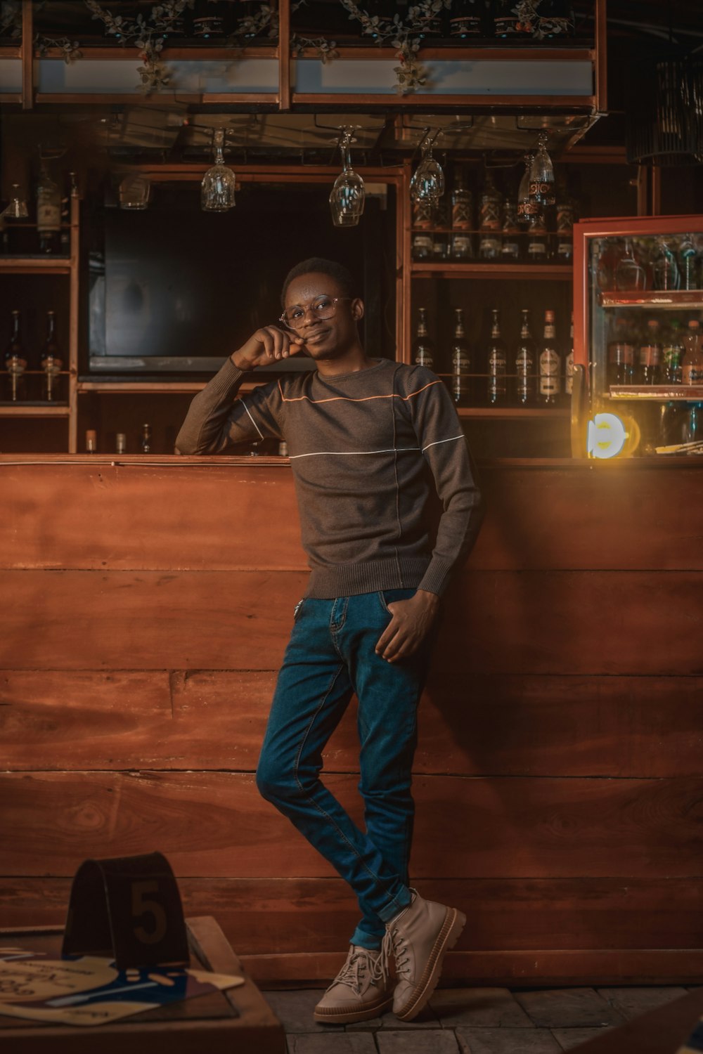 a man standing in front of a wooden bar