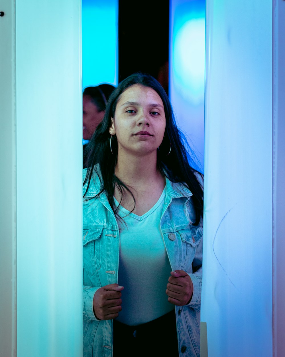 a woman standing in a room with a blue light behind her